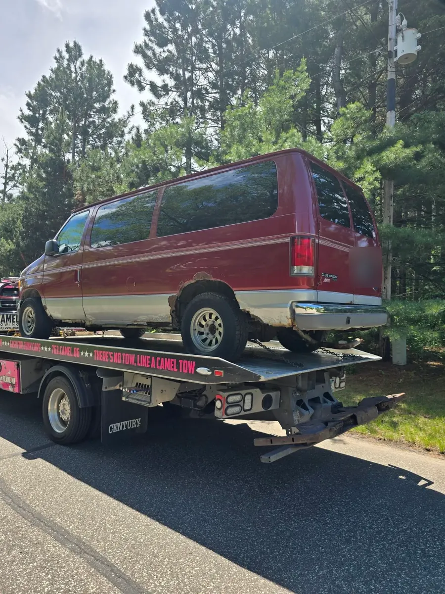Red Ford Club Wagon van loaded on a Camel Towing flatbed after a same-day pickup from Roseville